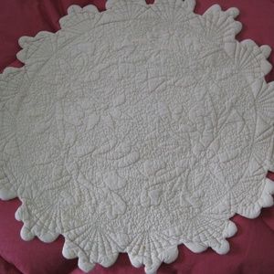 Set of 7 round cream colored quilted placemats.
